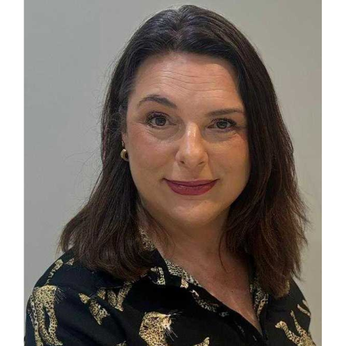 Headshot of a woman with shoulder-length dark hair, wearing a patterned blouse, smiling slightly against a neutral background.